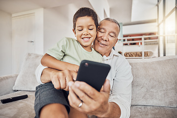 Image showing Grandfather, kid and phone on sofa in home playing games or old man learning social media from boy. Love, relax and grandpa with child on 5g mobile, app or smartphone web surfing and bonding together