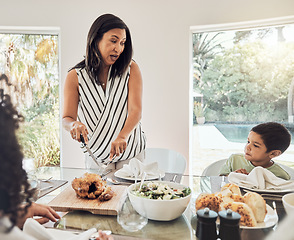 Image showing Grandmother talking to children in dining room, food ready for dinner and share family home recipe in Mexico. Elderly woman cutting chicken on table, eat healthy together and grandma with hungry kids