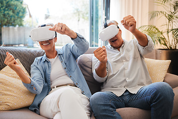 Image showing Senior couple with futuristic virtual reality technology on the sofa in their home. Retired man and woman using tech, digital gadgets and vr headset for 3d games and entertainment in the metaverse