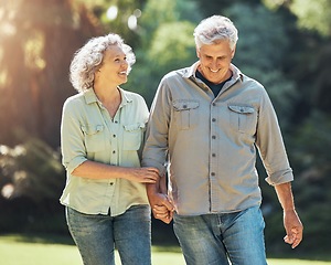 Image showing Nature, walk and a senior couple holding hands in park laughing and romance in retirement. Outdoor garden, love and elderly man and happy woman on romantic walking date in a field on summer weekend