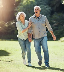 Image showing Senior couple walking in park, garden and sunshine to relax, wellness and fresh air in nature in Australia together. Happy man, smile woman and elderly people holding hands, enjoy retirement and love