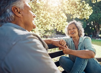 Image showing Elderly, couple and happy on bench in garden for conversation, bonding and happiness by trees in summer. Man, woman and retirement show love, relax and smile together in nature with sunshine at park