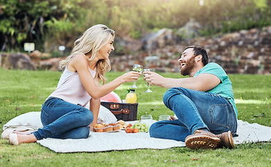 Image showing Couple, picnic and park of a man and woman cheers to happiness and love in nature. Happy people together with a smile enjoying alcohol and food laughing with quality time for an anniversary outdoor