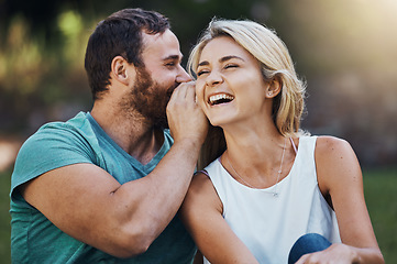 Image showing Gossip, secret and funny story with couple on a romantic date in nature in Australia in summer. Man talking in a whisper into the ear of a young laughing woman while happy in a garden together