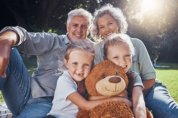 Image showing Family, children and teddy bear with a girl, grandparents and sister on the grass in a nature park during summer. Kids, haooy and love with senior man, woman and grandchildren outdoor in the day