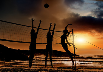 Image showing Sports, beach and volleyball at sunset by women silhouette jumping for ball together, fun, travel and summer. Energy, fitness and exercise with sports friends playing beach volleyball game in Brazil