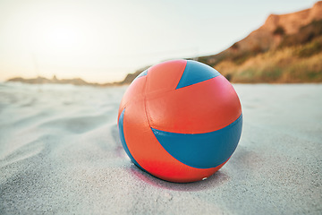 Image showing Beach, ball and volleyball on sand, a game at sunset at tropical ocean destination. Fitness, fun and summer sports at the sea in the evening. White sandy coast, a volley ball and an empty seascape.