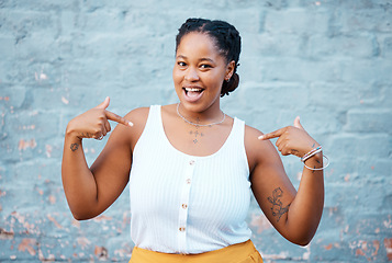 Image showing Black woman, pointing and happy feeling proud and self assured choosing herself against city building wall, mockup space or outside in Nigeria. Portrait of African model with a fun or playful gesture