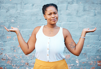 Image showing Portrait of confused black woman in doubt with a question and unsure gesture with arms up. Asking why, confusion and clueless girl with hands raised standing by a wall outside in urban town or city