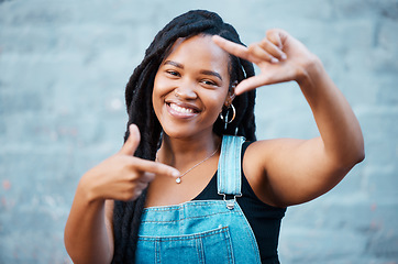 Image showing Black woman, hands and finger frame showing smile, happiness and face against city building wall, mockup space or outside in Atlanta. Portrait of female model with fun or playful gesture for beauty
