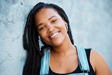 Image showing Black woman, face and freedom with a strong, independent or free female standing outdoor with a smile. Portrait of gen z with a millennial youth outside against a blue wall background