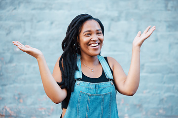 Image showing Black woman, smile and hands for confused or unsure gesture posing outside against urban city background in street against blue wall. Laughing female asking question showing and confused sign outside