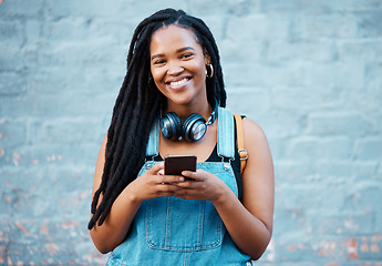 Image showing Black woman, happy and phone in city on travel, walk or adventure in urban street. Girl, smartphone and smile against wall in Atlanta on vacation, holiday or break while in communication online