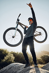 Image showing Man, mountain and bike celebrate, happy and excited after reaching summit in training. Cyclist, bicycle and rock in nature, lift hand and success in sport adventure for fitness on hill in Argentina