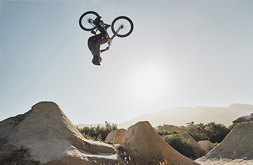 Image showing Mountain bike jump training man on rocks hill cycling in air, blue sky mockup for professional performance, training or outdoor bike exercise. Sports person on outdoor motorcycle or bicycle adventure