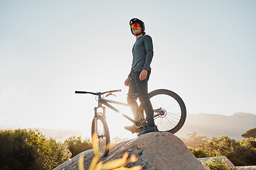 Image showing Mountain bike or motorcycle cyclist on rock for marathon goal, sports adventure or outdoor travel with sunglasses and helmet. Fitness training man with bicycle on a hill blue sky mockup in Australia