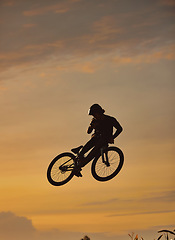 Image showing Mountain bike, cyclist and fitness jump at sunset in Colorado countryside nature in workout, exercise or training. Danger risk, extreme bmx sports or freedom cycling man in sunrise with stunt energy