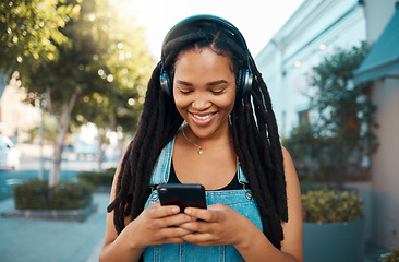 Image showing Black woman, music headphones and phone with smile for 5g communication and audio streaming outdoors. Happy African female smiling, listening to playlist, texting and social media in South Africa