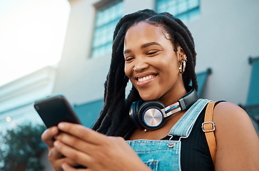 Image showing Black woman with a phone in the city, search for online podcast or radio, happy looking for music to listen to. Freedom, relax and smile by African American female enjoying free time and streaming