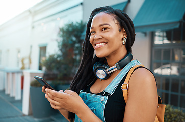 Image showing Student, phone and black woman in street with headphones on walk to college in south africa. Happy, smile and beautiful african girl in outdoor city road networking on social media with smartphone.