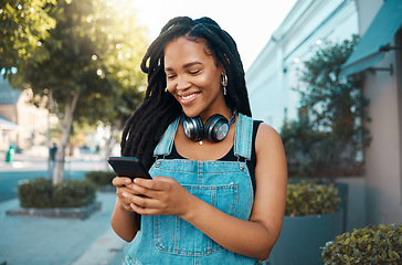 Image showing Phone, social media and music with a woman in the city using her mobile for streaming, audio or communication. Web, internet and networking with a young female reading or typing a text message