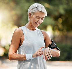 Image showing Senior woman, fitness and watch of running time in health and wellness for cardio exercise in nature. Active elderly female runner checking smartwatch to monitor training results in sports workout