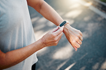 Image showing Senior woman, fitness runner with smartwatch for results, health and wellness on road exercise, training or run workout. Watch, running elderly athlete and street, city or check for marathon time