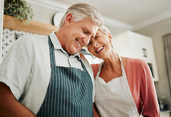 Image showing Senior couple, love and cooking while wearing an apron, laughing and happy bonding together in their home kitchen and enjoying healthy relationship. Old man and woman enjoying retirement with a smile