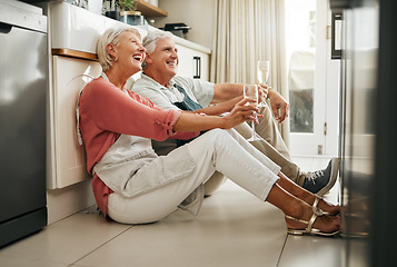 Image showing Senior couple, wine and laughing on kitchen floor thinking happy memories and talking about love during a celebration of anniversary, new home or retirement. Old man and woman telling a funny joke