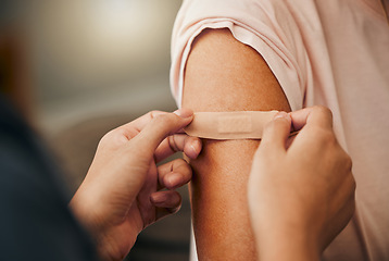 Image showing Covid, vaccine and plaster with a doctor and patient consulting in an appointment or checkup at home. Nurse, healthcare and trust with a health professional using a bandaid on an arm after medication