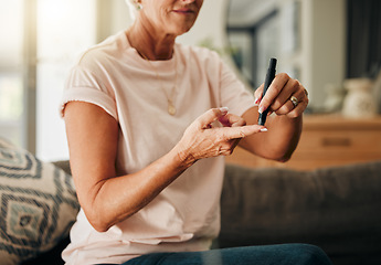 Image showing Diabetes, health and elderly woman doing a blood sugar test on her finger with a glucometer. Sickness, healthcare and diabetic senior lady checking her glucose level sitting on a sofa at home.