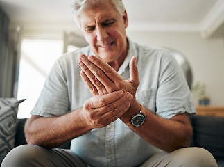 Image showing Hands, pain and arthritis with a senior man holding his hand while suffering from osteoporosis, cramp or injury. Health, medical and joint with an elderly male pensioner in the living room at home