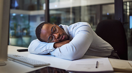 Image showing Black man in business, tired and sleeping on night office desk after programming computer code, database seo or cybersecurity. Burnout, exhausted and sleepy worker with documents deadline in Nigeria