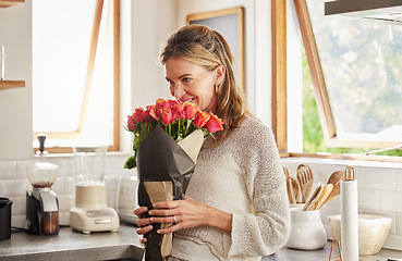 Image showing Flowers, smile, and elderly woman smelling rose in a kitchen, surprised by sweet gesture and or secret gift. Happy, romantic and kind surprise for mature, excited woman on valentines morning