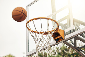 Image showing Basketball, net and ball flight in sports game outdoors for match in the USA. Sport and airball of throw to score point for win, victory against fiberglass board outside in a urban town or courtyard