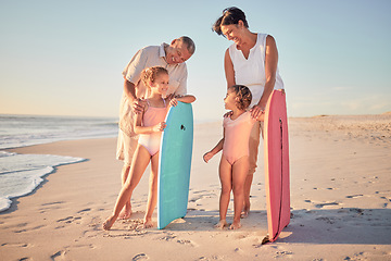 Image showing Family, beach and surf with children and parents on the sand by the ocean or sea for surfing, fun and holiday. Water, love and summer with a man, woman and kids on summer vacation at the coast