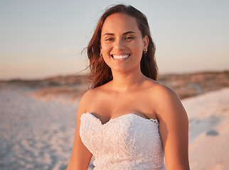 Image showing Portrait of a bride at beach wedding at sunset, happy and relax in outdoor nature. Freedom, elegance and celebration by just married woman enjoying walk after marriage ceremony, smiling and cheerful