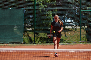 Image showing A young girl showing professional tennis skills in a competitive match on a sunny day, surrounded by the modern aesthetics of a tennis court.