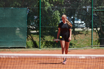 Image showing A young girl showing professional tennis skills in a competitive match on a sunny day, surrounded by the modern aesthetics of a tennis court.