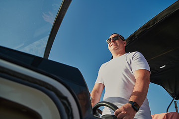 Image showing Man on luxurious yacht on the open sea, relaxing in the warmth of the sun, as they enjoy a day filled with adventure and friendship.