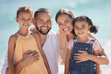 Image showing Family, happy at the beach and smile out in the sun while they enjoy and love to spend quality time together. Dad and mom hug kids, they bond and have fun on summer vacation in portrait.