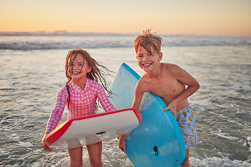 Image showing Happy children, beach and learning to surf for fun and bonding on bali summer vacation. Kids, boy and girl siblings on tropical holiday while surfing with board for water sports, splash and swim
