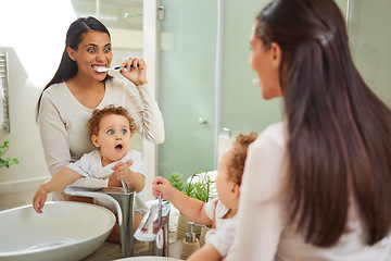 Image showing Dental, teeth and health with a mother and baby brushing teeth in the bathroom of their home together. Children, oral hygiene and healthcare with a woman and her son using a toothbrush in the morning