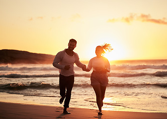 Image showing Ocean, holiday and sunset, running couple on beach happy holding hands. Love, romance and man and woman run in evening sun. Romantic vacation, spend time together and playing in nature and fun at sea