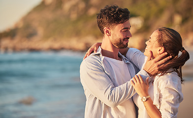 Image showing Love, beach and couple embrace at sunset for romantic summer evening date together in nature. Happy, sweet and satisfied people in relationship make eye contact for affection and care.