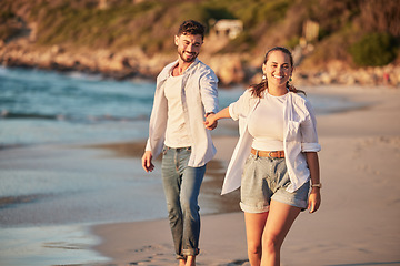 Image showing Nature, water and a couple walking on beach sand in summer sun. Love, freedom and a man and woman on ocean holiday holding hands. Sea, sunshine and free time, happy guy and girl walking on shore.