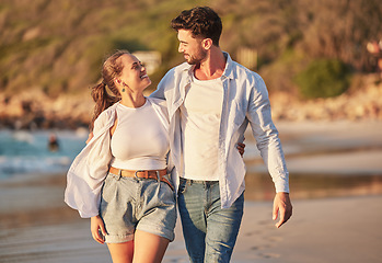 Image showing Summer, love and couple at a beach on vacation, bonding and laughing while walking along the sea at sunset. Freedom, nature and travel by happy and relax man and woman enjoying romantic ocean walk