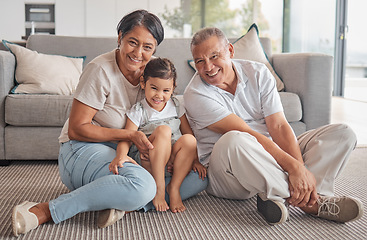 Image showing Girl, hug and grandparents with love, care and relax in family home together. Portrait of happy child, smile senior grandma and laugh elderly grandpa bond and play together in the living room floor