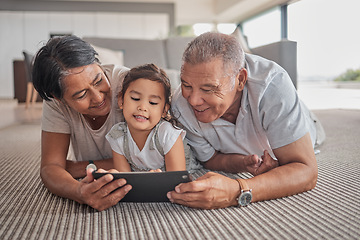 Image showing Relax, grandparents and cartoon on tablet with child on home floor together in the Philippines. Filipino family bonding time with grandfather, grandmother and grandchild watching animation online.