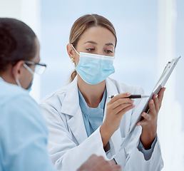 Image showing Consulting, patient and doctor with mask and documents about health, chart and results. Health, covid and physician helps patient with vaccine forms, pandemic safety regulations or rules at hospital